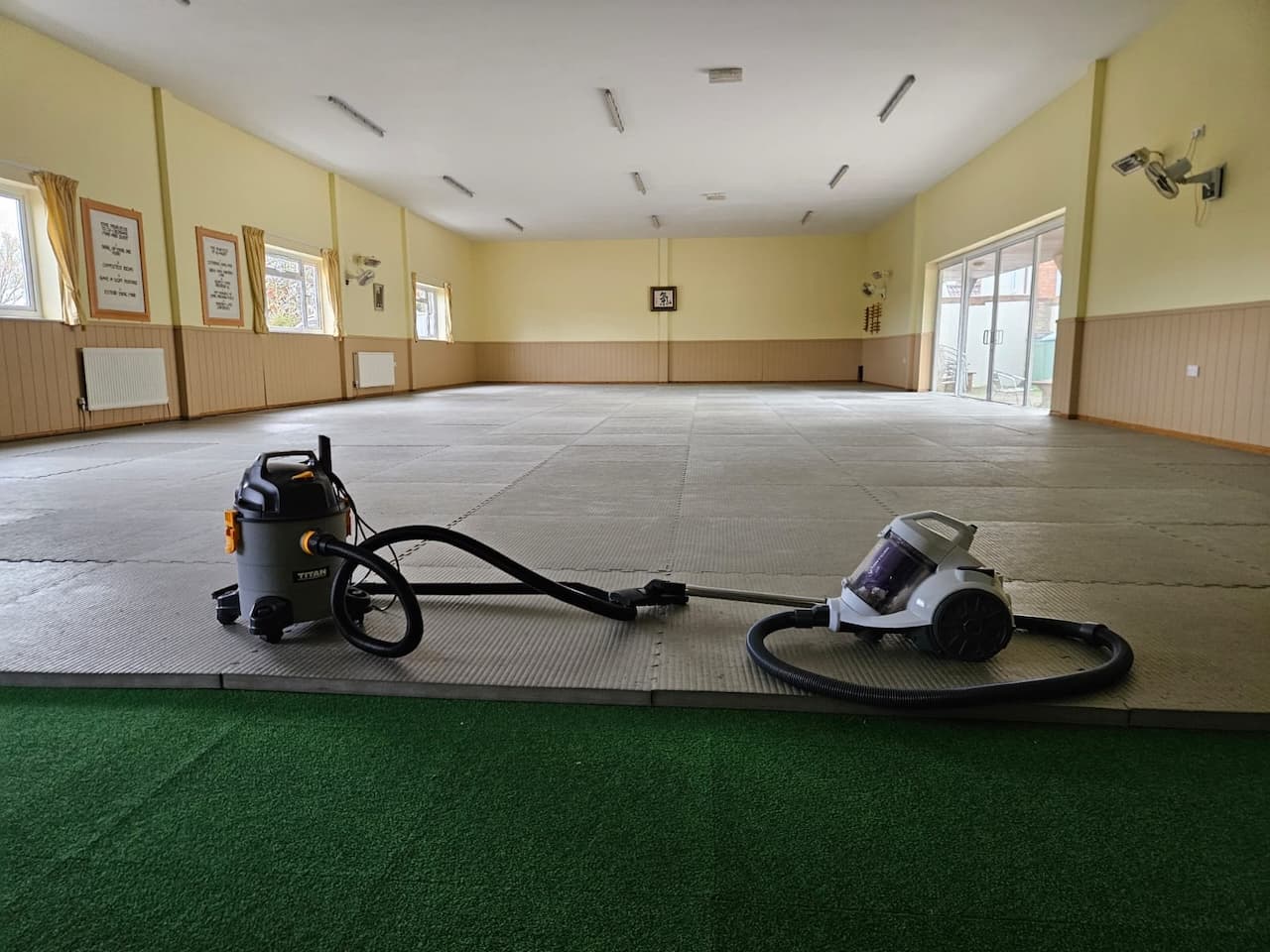 Two hoovers waiting for people to clean the mat
